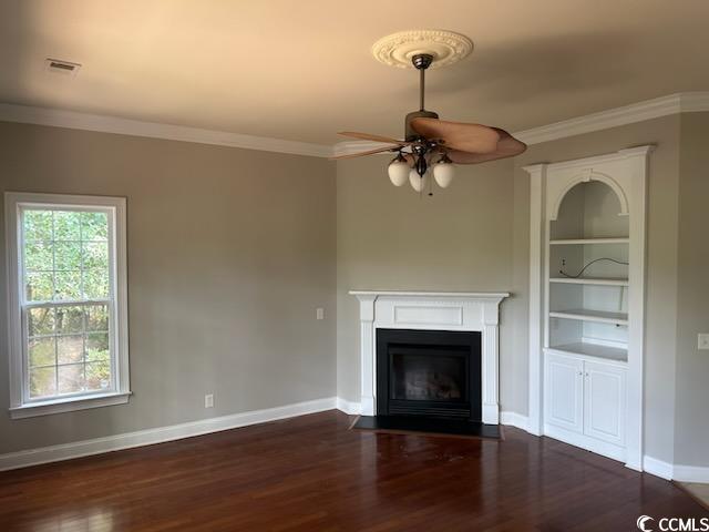 unfurnished living room featuring dark hardwood / wood-style flooring, ceiling fan, and crown molding