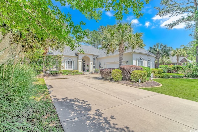 mediterranean / spanish-style home with a front yard and a garage