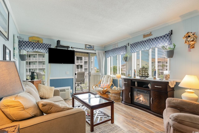 living room with ornamental molding, a textured ceiling, and light wood-type flooring