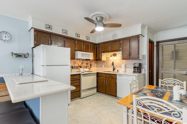 kitchen with backsplash, ceiling fan, sink, white appliances, and a textured ceiling