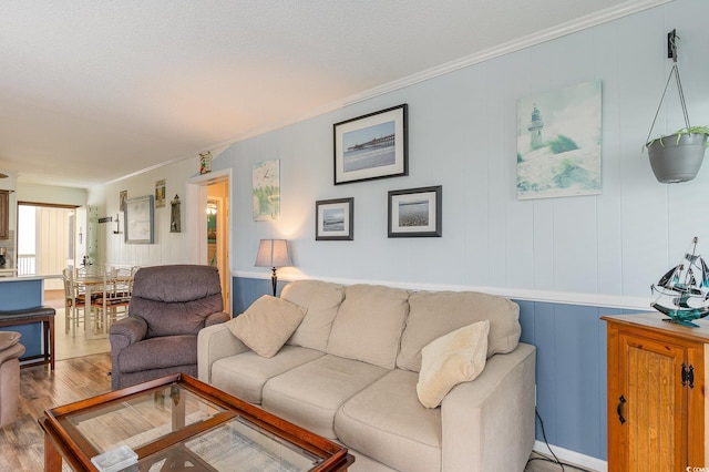 living room featuring ornamental molding and wood-type flooring