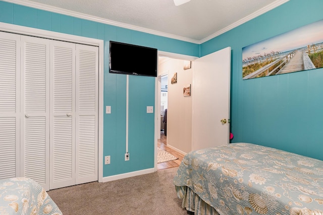 carpeted bedroom with crown molding and a closet