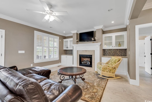 living room featuring light wood-type flooring, ceiling fan, and ornamental molding