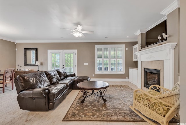 living room with ceiling fan, crown molding, and light hardwood / wood-style flooring