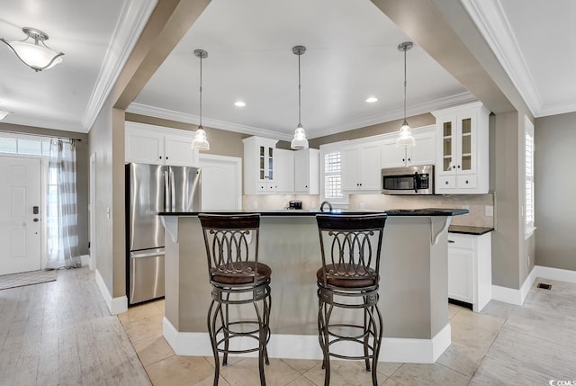 kitchen featuring white cabinets, pendant lighting, and appliances with stainless steel finishes