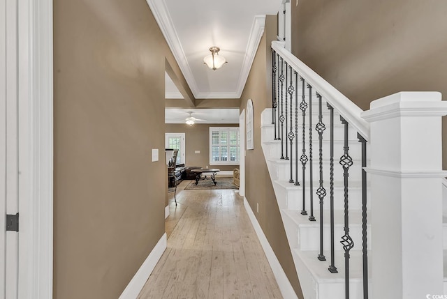 foyer featuring ceiling fan, light hardwood / wood-style floors, ornamental molding, and beam ceiling