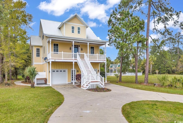 raised beach house featuring a front yard, a porch, and a garage