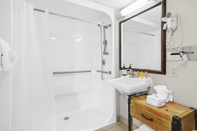 bathroom with tile patterned flooring, a shower with curtain, and sink