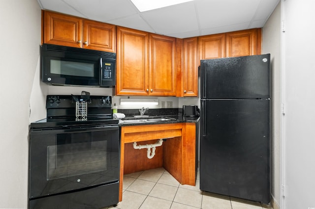 kitchen with black appliances, sink, and light tile patterned floors