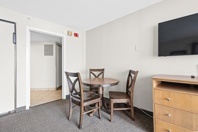 dining room featuring dark carpet and a textured ceiling