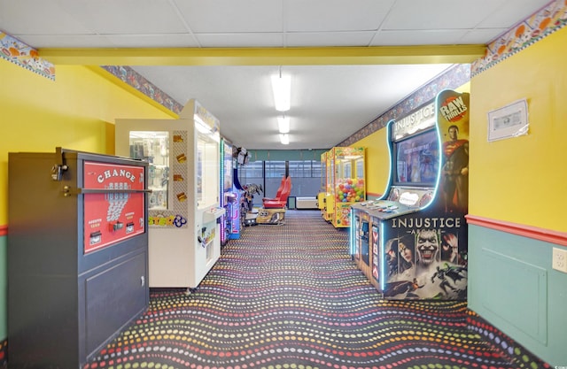 recreation room with a paneled ceiling, carpet, and a baseboard heating unit