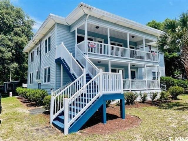 rear view of property with covered porch and a balcony