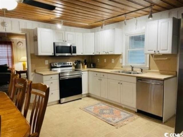 kitchen featuring appliances with stainless steel finishes, white cabinetry, sink, and wooden ceiling