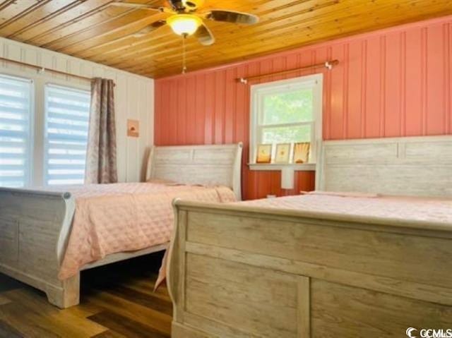 bedroom with wood walls, dark wood-type flooring, wood ceiling, and ceiling fan