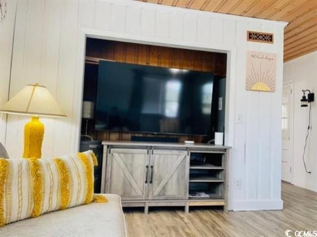 living room with wood ceiling, wood walls, and hardwood / wood-style flooring