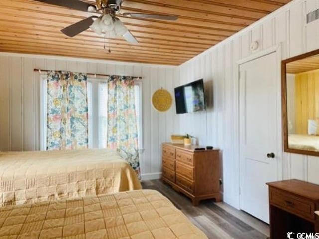 bedroom featuring wood ceiling, wood walls, dark hardwood / wood-style flooring, and ceiling fan