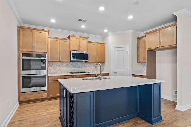 kitchen featuring stainless steel appliances, light hardwood / wood-style floors, a center island with sink, and sink