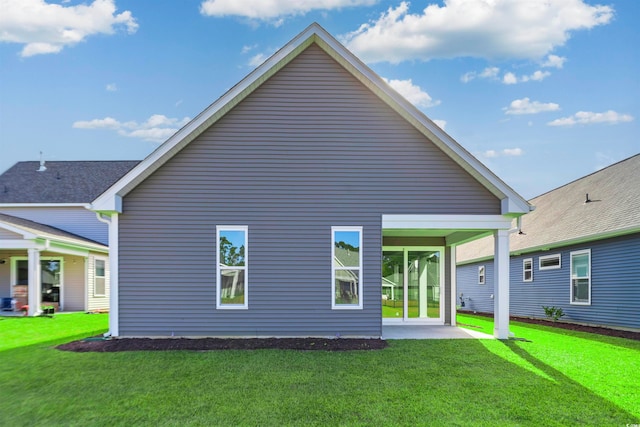 back of house featuring a patio and a yard