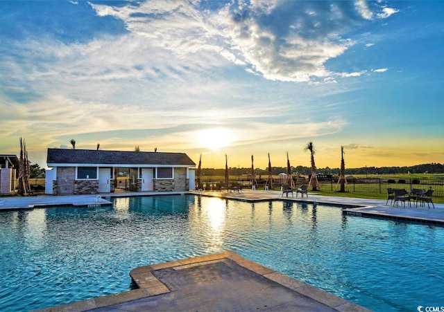 pool at dusk with a patio