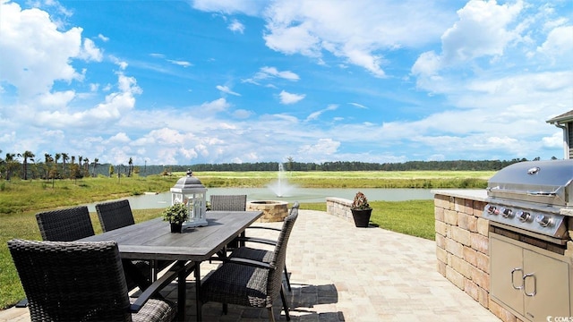 view of patio with a grill and a water view