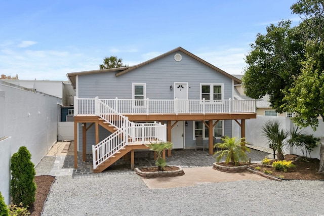 rear view of property featuring a wooden deck and a patio area