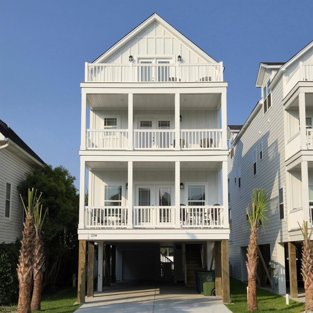 113A 12th Ave S, Surfside Beach, SC 29575 - coastal home featuring a balcony, french doors, board and batten siding, driveway, and a carport