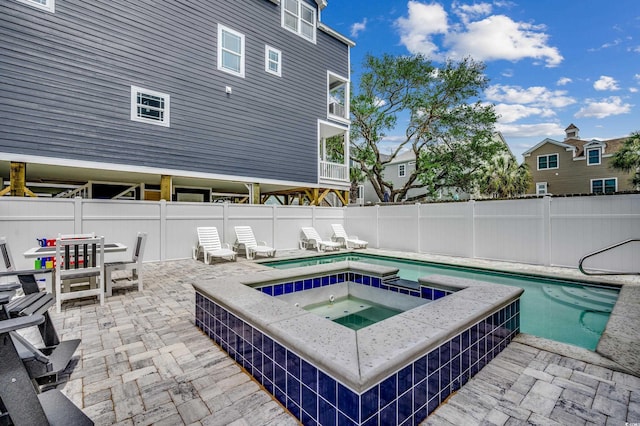 view of pool featuring a patio, a fenced backyard, and a pool with connected hot tub