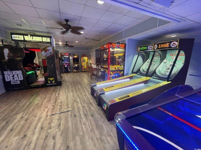 game room with a drop ceiling, ceiling fan, and hardwood / wood-style floors