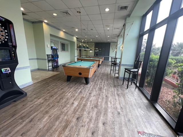 rec room with a drop ceiling, pool table, and hardwood / wood-style floors