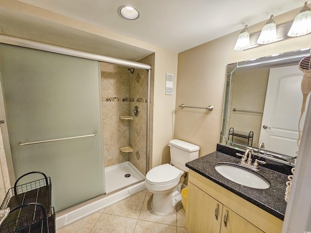 bathroom featuring tile patterned floors, an enclosed shower, vanity, and toilet