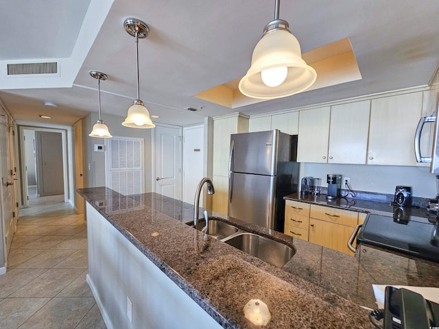 kitchen featuring a raised ceiling, pendant lighting, appliances with stainless steel finishes, light tile patterned floors, and sink