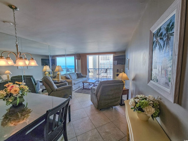 living room featuring light tile patterned floors, expansive windows, and a notable chandelier