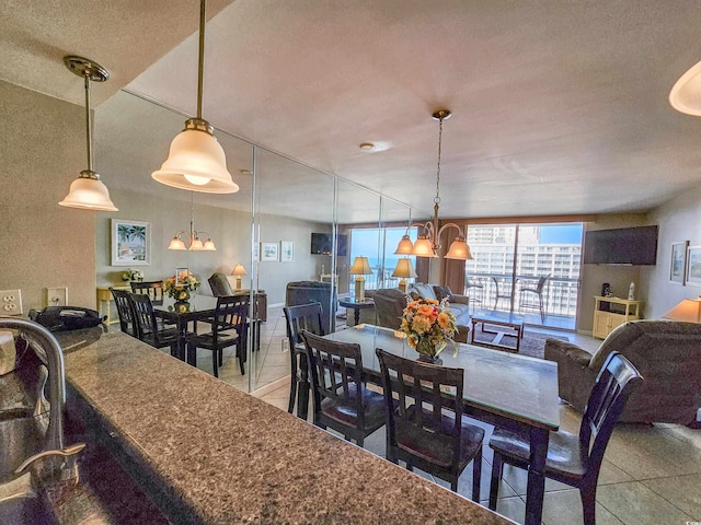 tiled dining room featuring a textured ceiling and an inviting chandelier