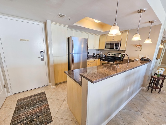 kitchen with pendant lighting, light brown cabinetry, appliances with stainless steel finishes, light tile patterned floors, and kitchen peninsula