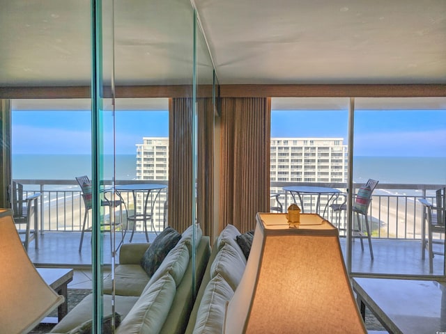 living room featuring a beach view, a healthy amount of sunlight, and a water view