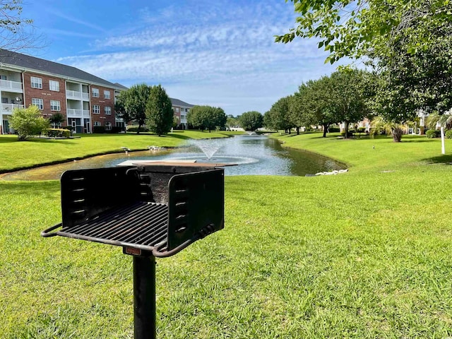 view of property's community with a lawn and a water view