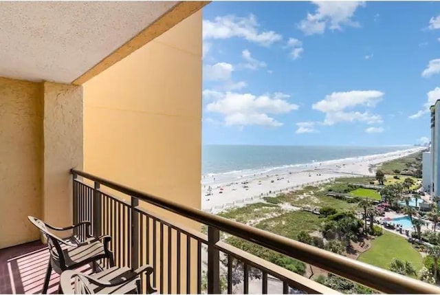 balcony featuring a view of the beach and a water view