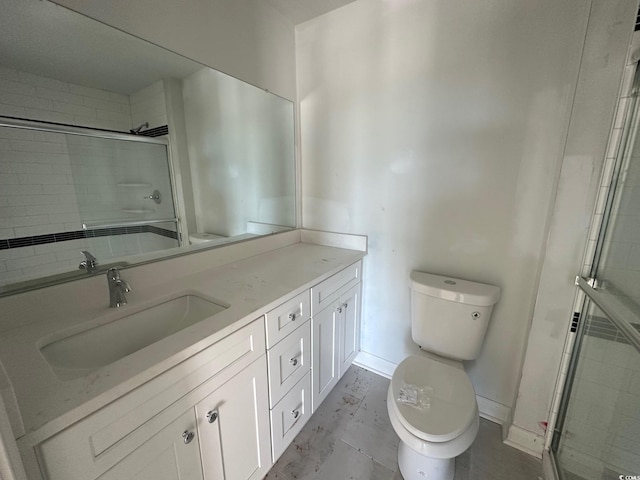 bathroom with vanity, a shower with shower door, and toilet