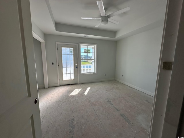 spare room featuring a tray ceiling and ceiling fan