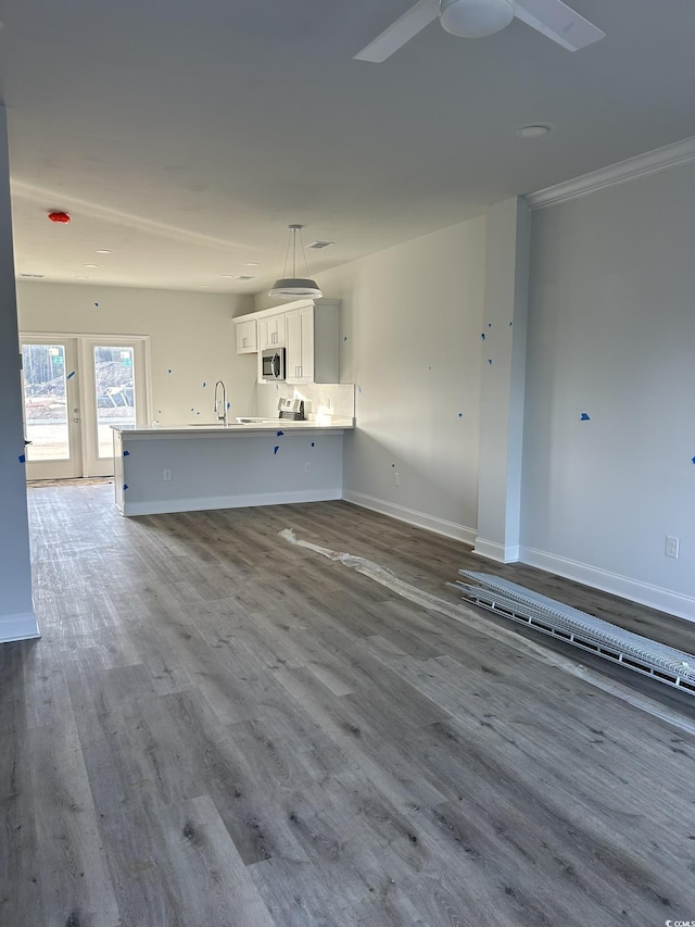 unfurnished living room featuring sink and hardwood / wood-style flooring