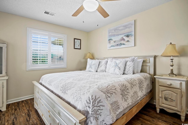 bedroom featuring dark hardwood / wood-style floors, ceiling fan, and a textured ceiling