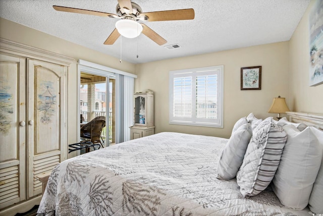 bedroom with ceiling fan, a textured ceiling, and access to exterior