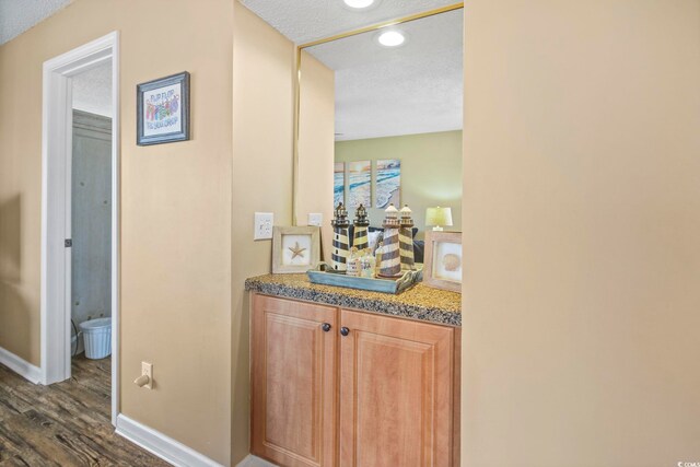 hallway featuring dark hardwood / wood-style floors and a textured ceiling