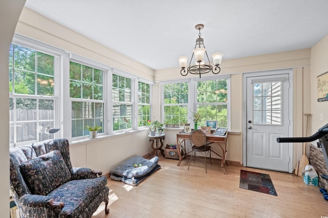 sunroom / solarium featuring an inviting chandelier