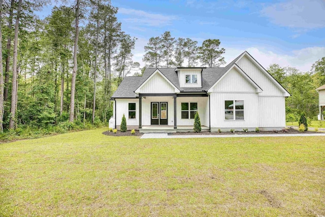 modern inspired farmhouse with a front yard and covered porch