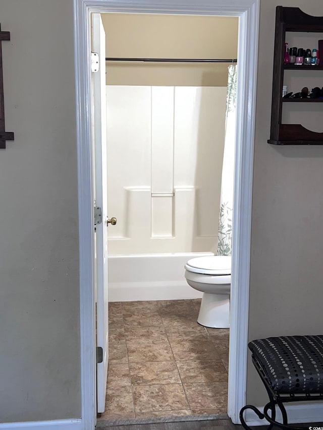 bathroom with shower / bathtub combination with curtain and toilet