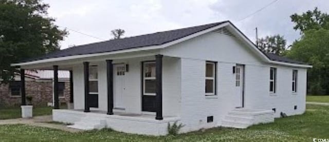 exterior space with covered porch and a yard