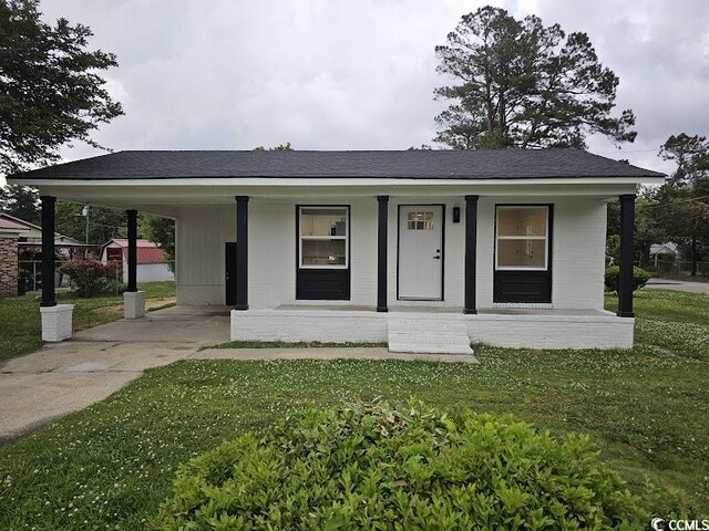 single story home featuring a front lawn, covered porch, and a carport