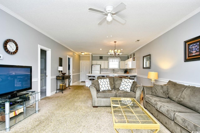 living room featuring ceiling fan with notable chandelier and crown molding