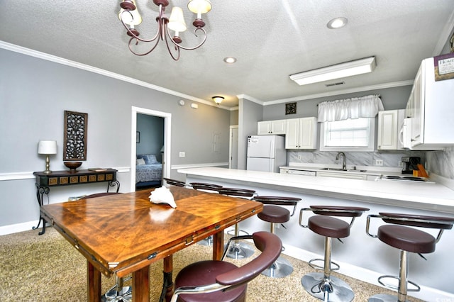 kitchen featuring a chandelier, tasteful backsplash, crown molding, sink, and white appliances